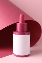 Photo of Bottle of skin care product on pink background