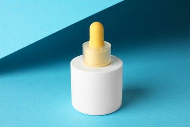 Photo of Bottle of skin care product on light blue background