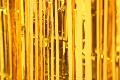 Photo of Golden foil curtain as background, closeup view