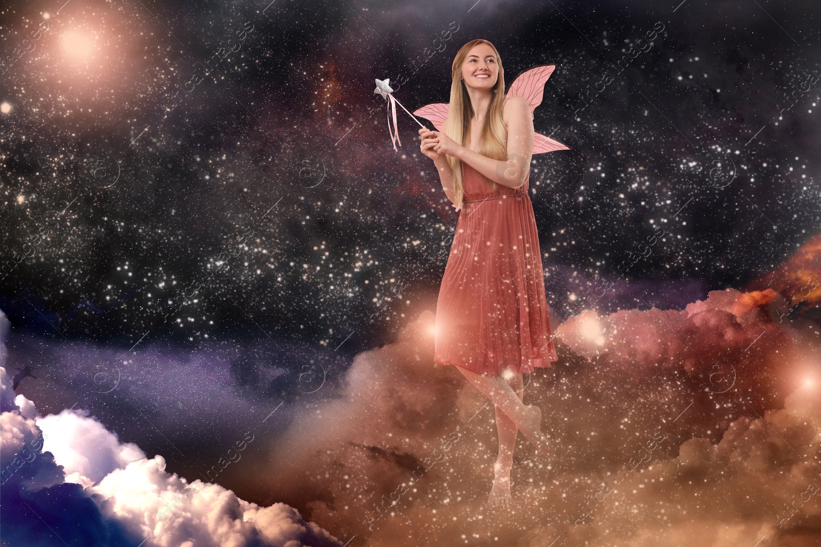 Image of Ethereal fairy with magic wand among fluffy clouds in dark sky. Beautiful girl with wings