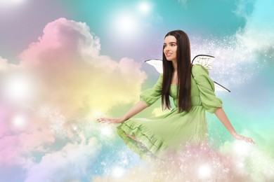 Image of Ethereal fairy casting magic lights among fluffy clouds in colorful sky. Beautiful girl with wings