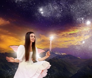 Enchanting fairy igniting lights in dark sky with magic wand. Beautiful girl with wings