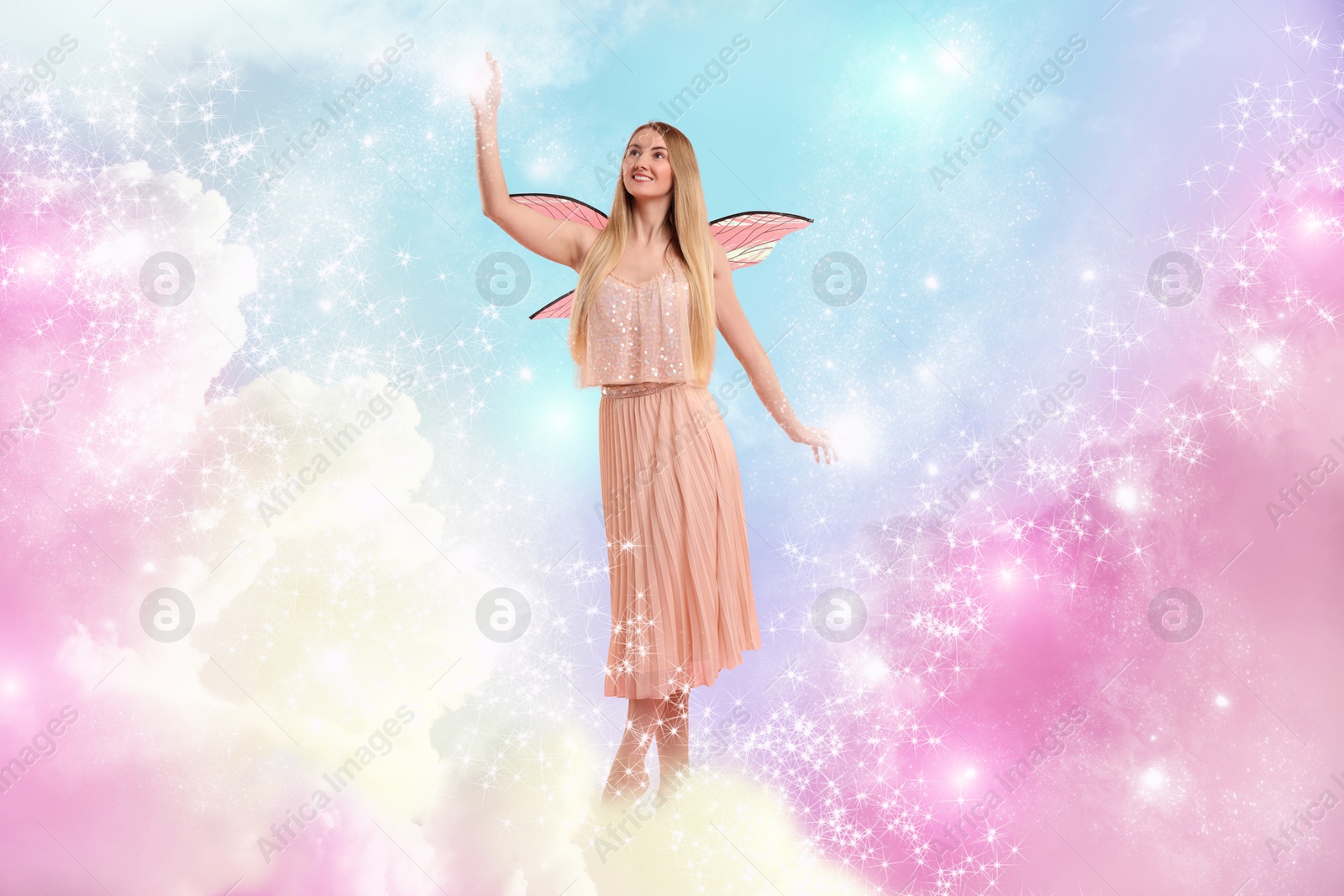 Image of Ethereal fairy casting magic lights among fluffy clouds in colorful sky. Beautiful girl with wings