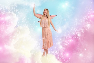 Image of Ethereal fairy casting magic lights among fluffy clouds in colorful sky. Beautiful girl with wings