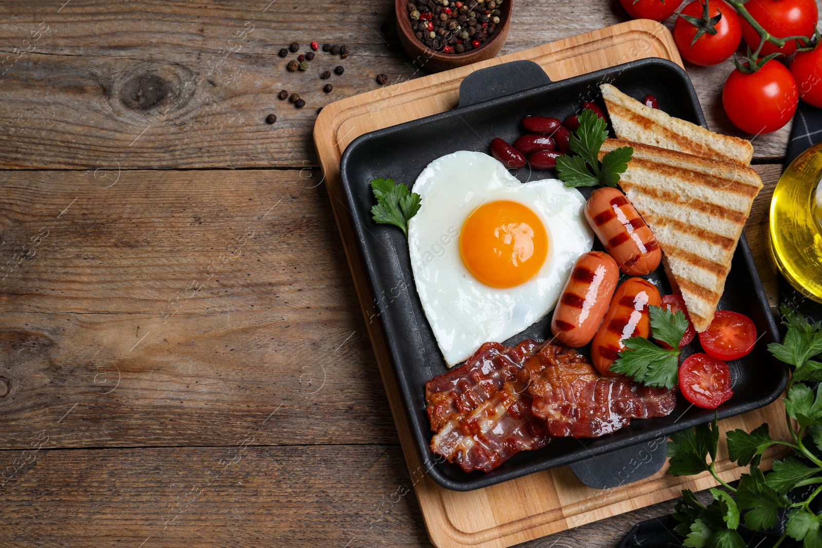 Photo of Delicious breakfast with heart shaped fried egg and  sausages served on wooden table, flat lay. Space for text