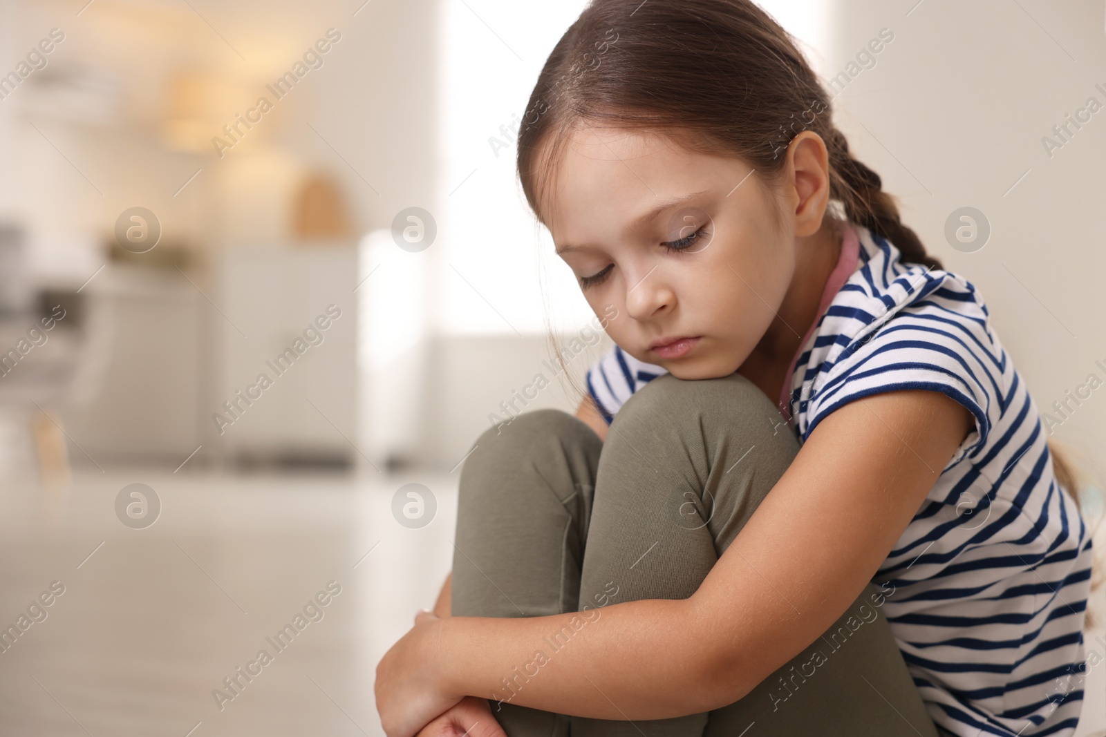 Photo of Orphanage concept. Portrait of sad girl in room