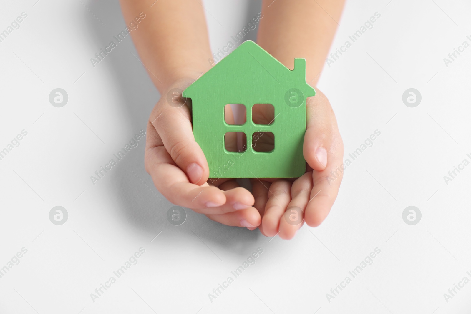 Photo of Adoption concept. Kid with cutout of house at white table, closeup