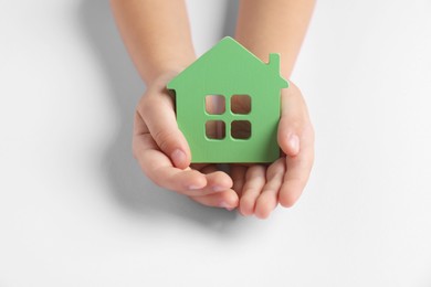 Photo of Adoption concept. Kid with cutout of house at white table, closeup