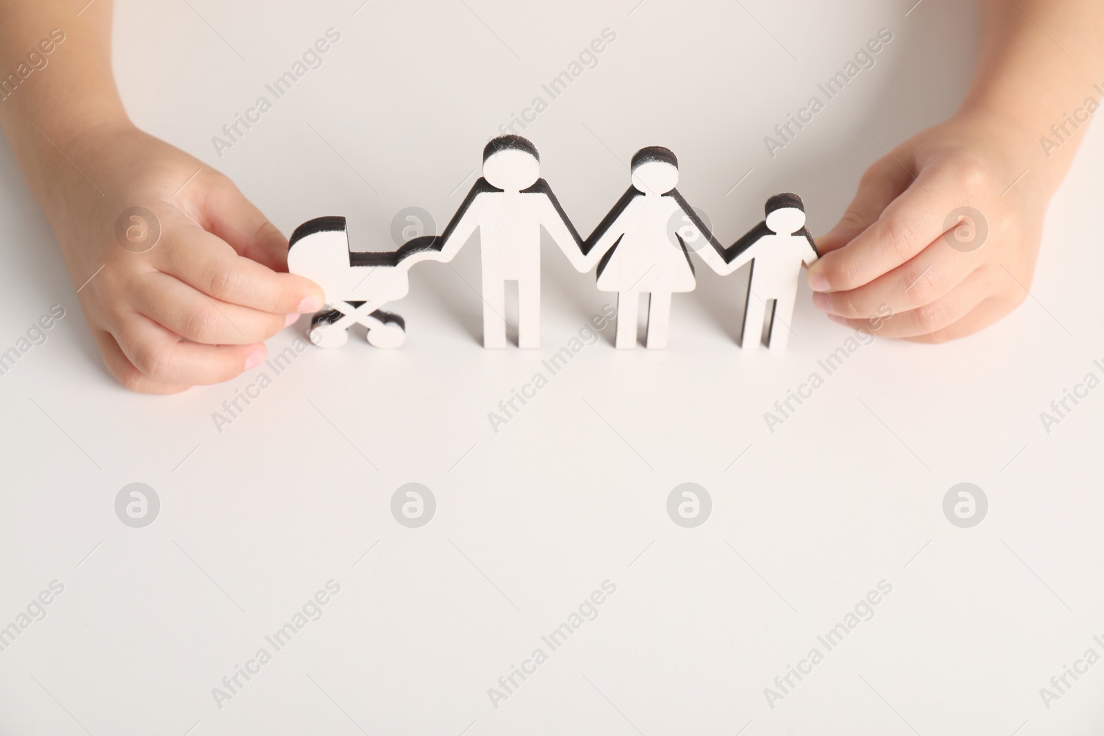 Photo of Adoption concept. Kid with cutout of family at white background, closeup. Space for text