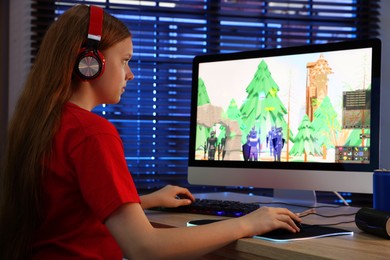 Photo of Girl playing video game with keyboard and mouse at table in dark room