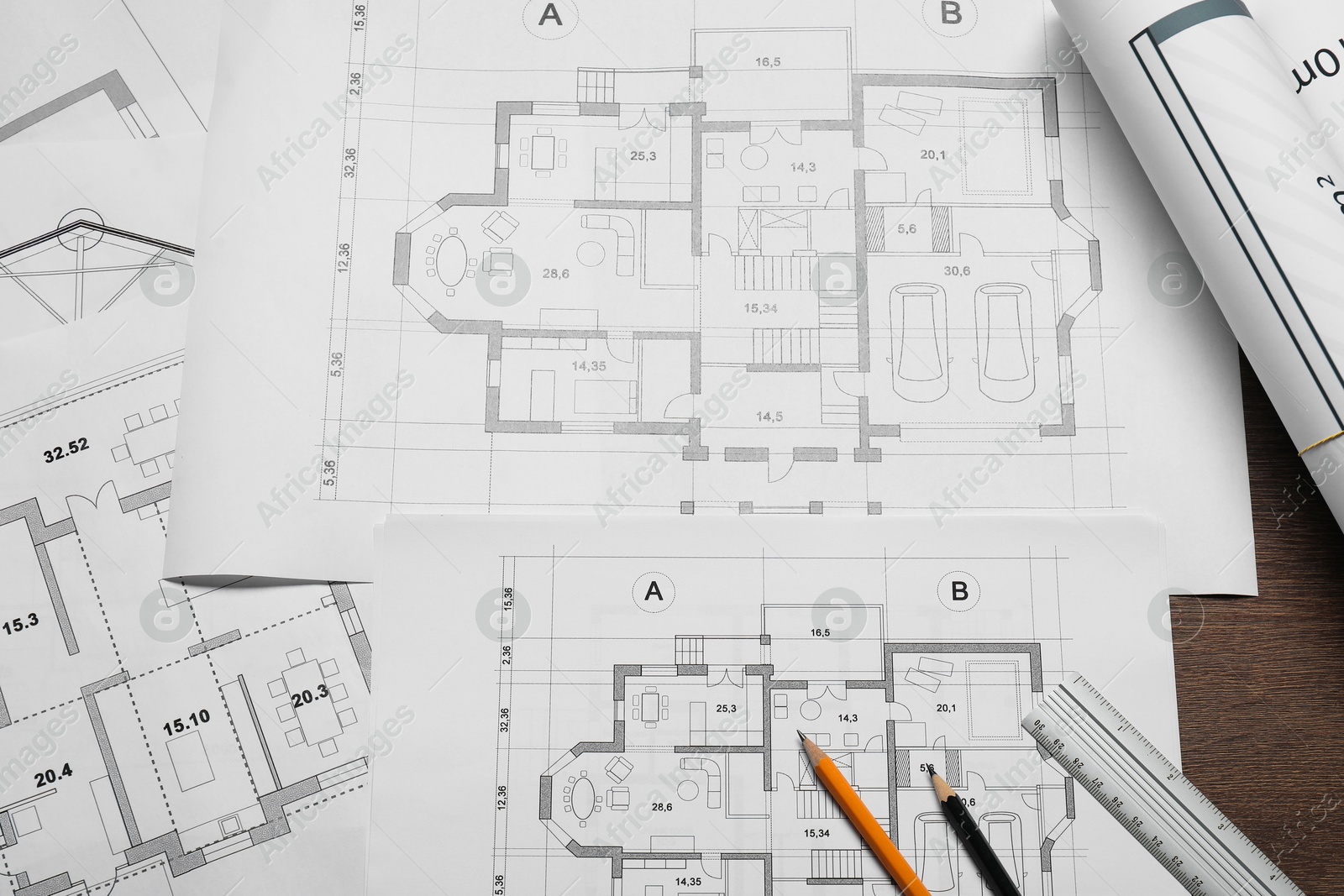 Photo of Different architectural drawings, ruler and pencils on wooden table, top view