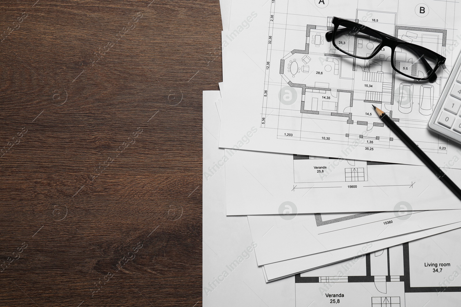 Photo of Different architectural drawings, glasses and pencil on wooden table, top view. Space for text