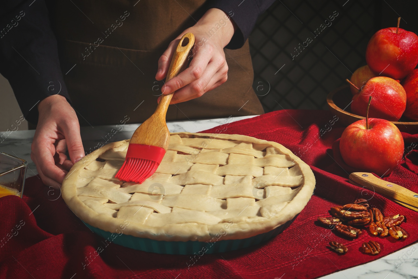 Photo of Woman making homemade apple pie at white marble table, closeup