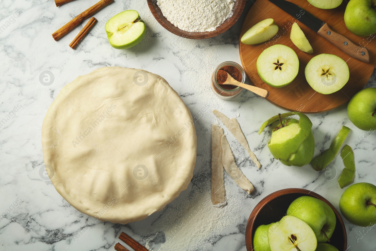 Photo of Flat lay composition with raw homemade apple pie and ingredients on white marble table