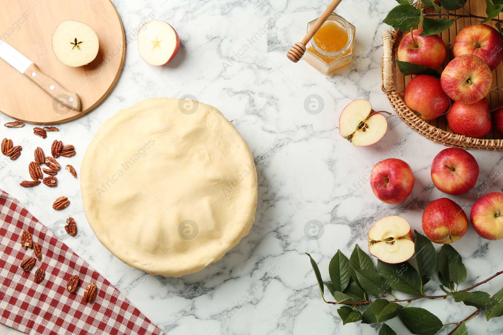 Photo of Flat lay composition with raw homemade apple pie and ingredients on white marble table