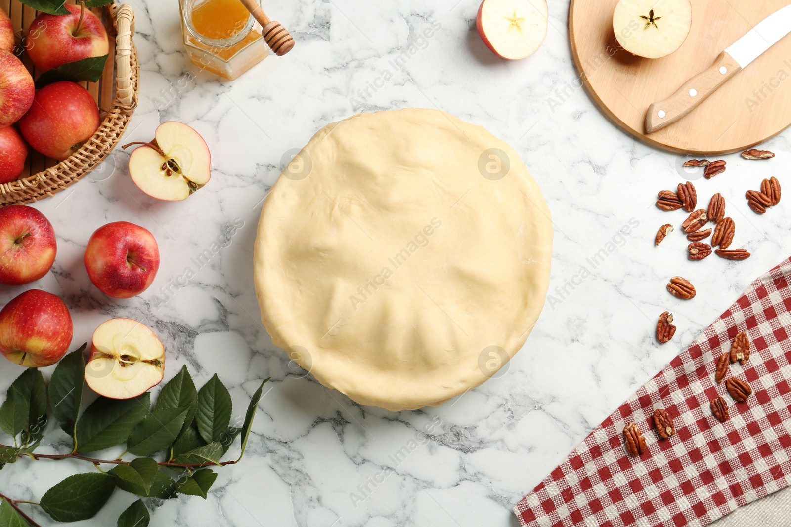 Photo of Flat lay composition with raw homemade apple pie and ingredients on white marble table