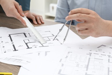 Architects working with project, closeup. Different technical drawings on wooden table