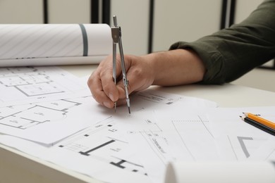 Photo of Architect working with project, closeup. Different technical drawings on table