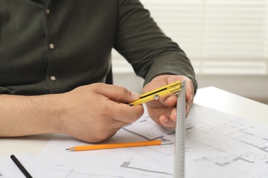 Photo of Architect working with project, closeup. Different technical drawings on table