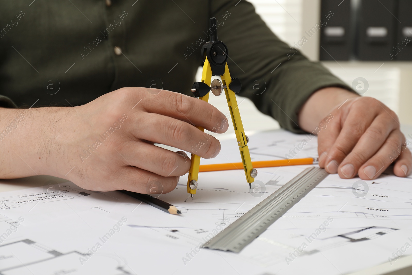 Photo of Architect working with project, closeup. Different technical drawings on table