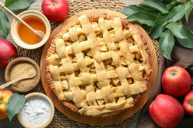 Photo of Flat lay composition with tasty homemade apple pie and ingredients on table