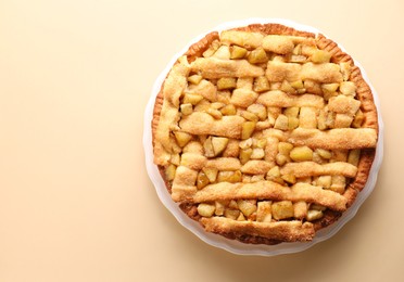 Photo of Tasty homemade apple pie on beige background, top view. Space for text