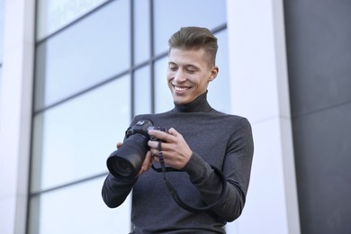 Photo of Professional photographer with camera near building outdoors