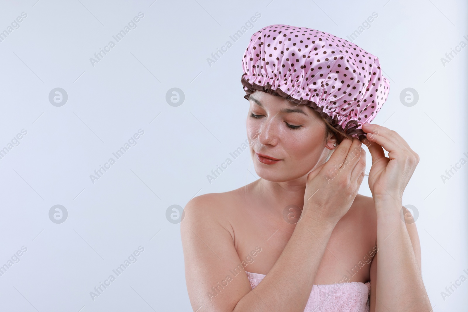 Photo of Woman wearing shower cap on white background, space for text