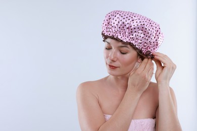 Photo of Woman wearing shower cap on white background, space for text