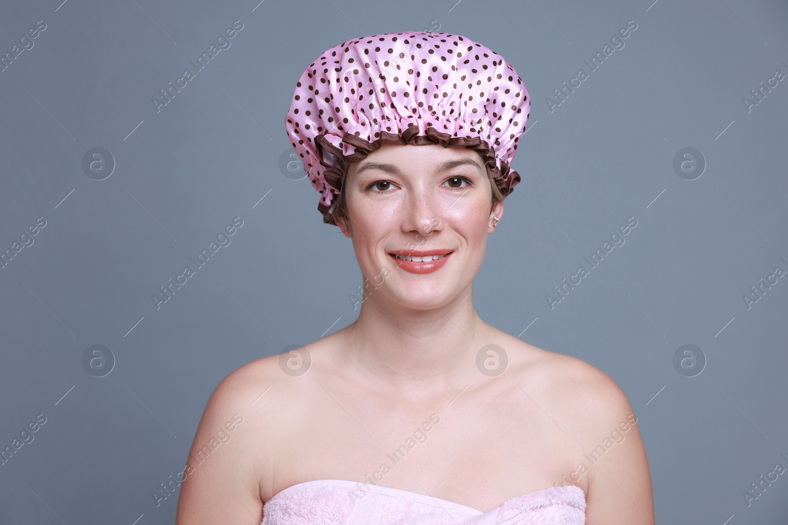 Photo of Happy woman in shower cap on grey background