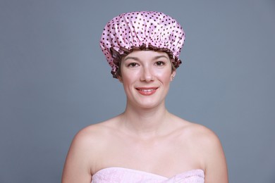 Photo of Happy woman in shower cap on grey background