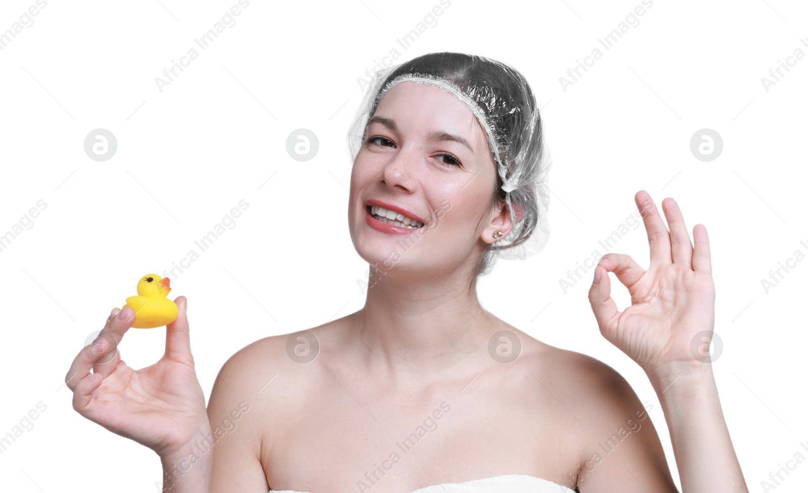 Photo of Woman with shower cap and bath duck showing ok gesture on white background