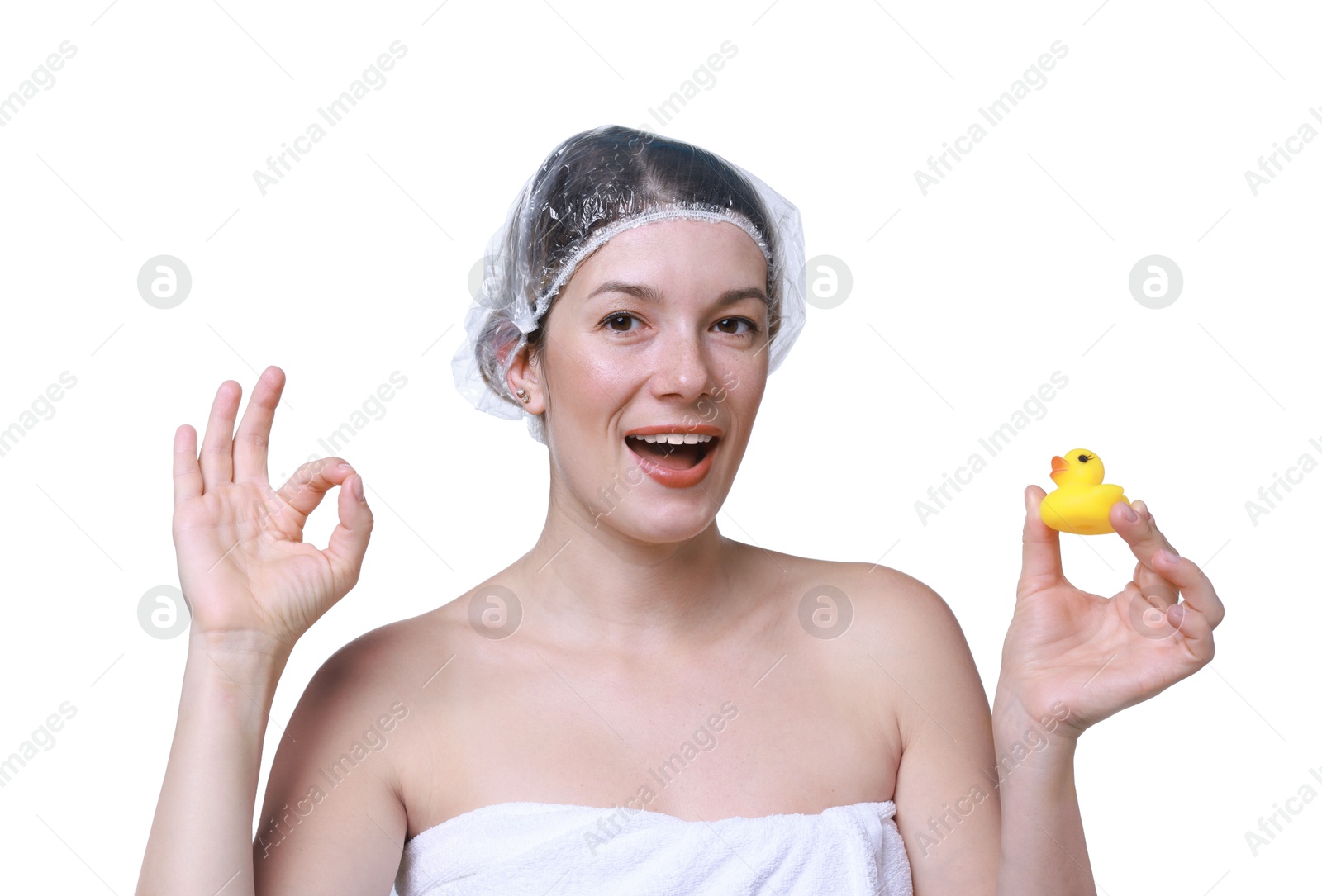 Photo of Woman with shower cap and bath duck showing ok gesture on white background