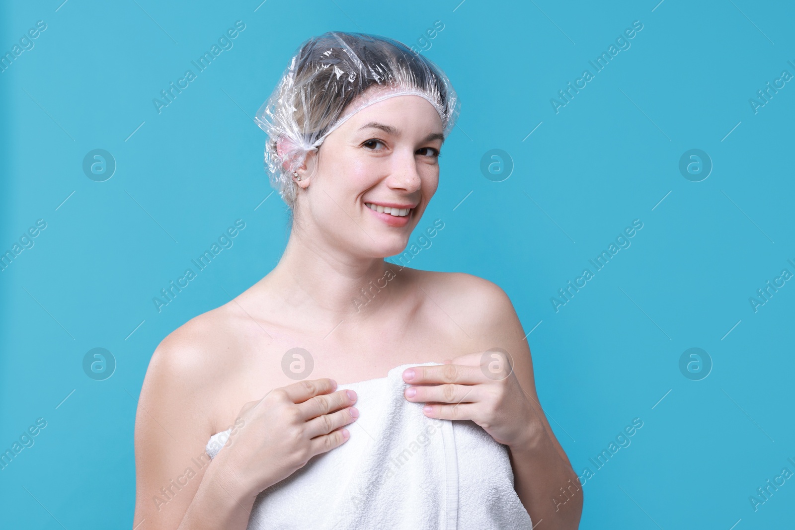 Photo of Woman in shower cap on light blue background