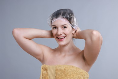 Photo of Woman wearing shower cap on grey background