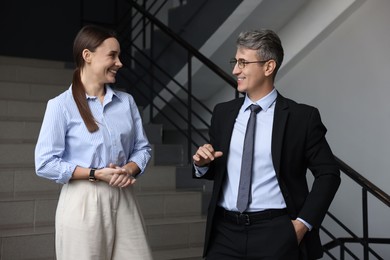 Coworkers talking while going down stairs in office