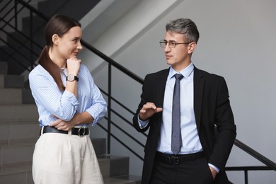 Coworkers talking while going down stairs in office