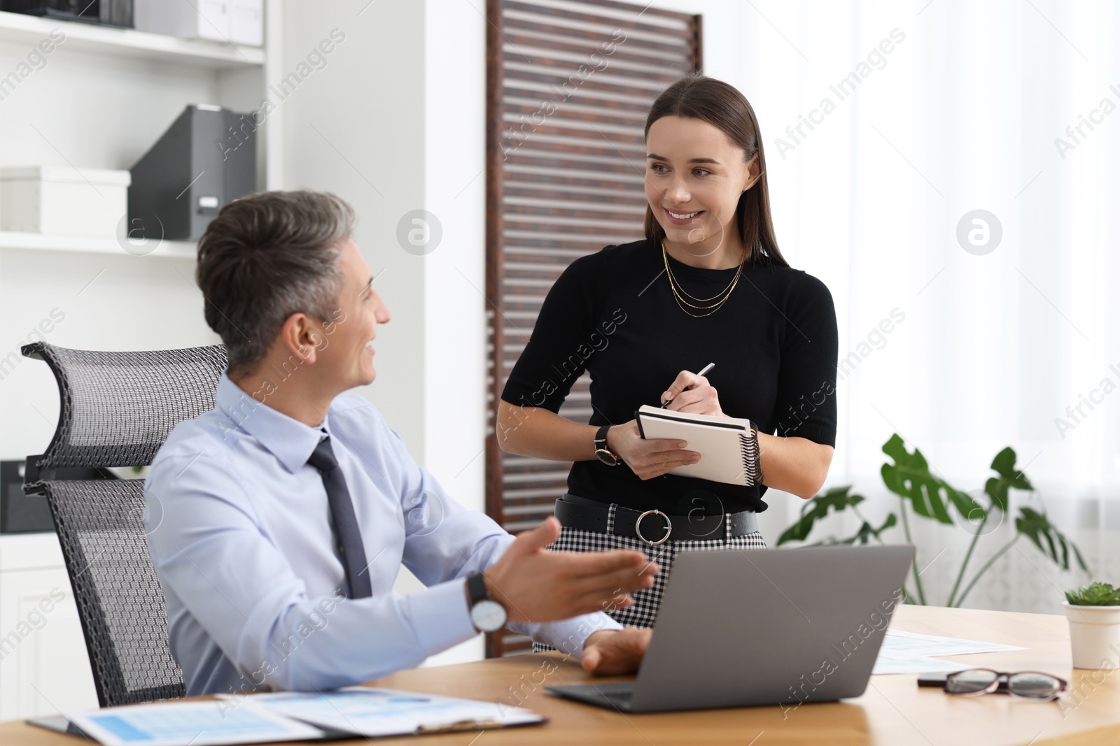 Photo of Coworkers working together at table in office