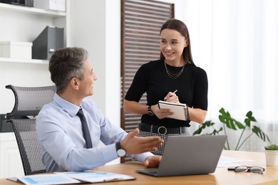 Photo of Coworkers working together at table in office