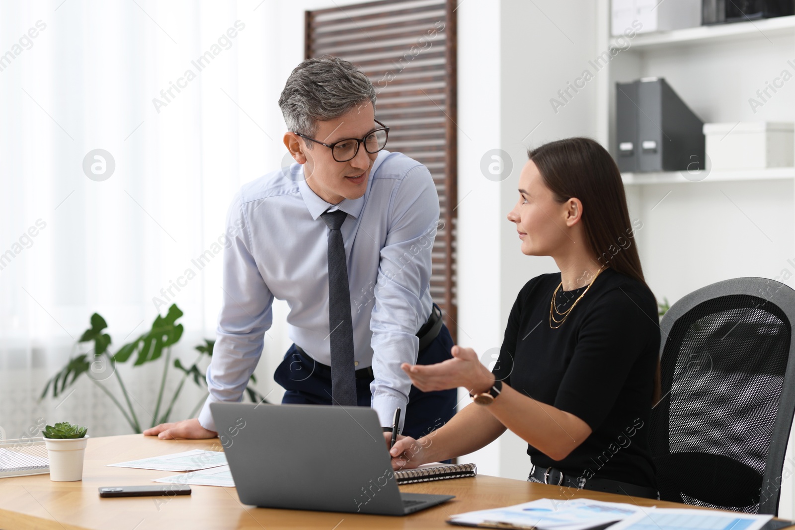 Photo of Coworkers working together at table in office