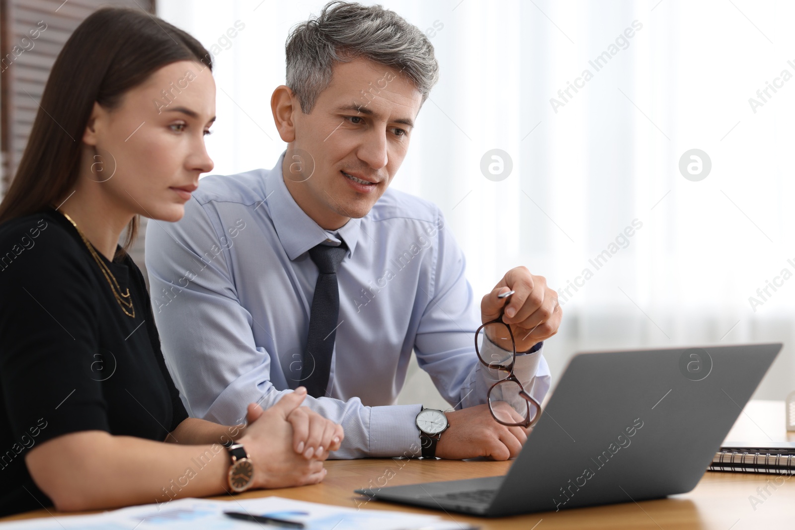 Photo of Coworkers working together at table in office