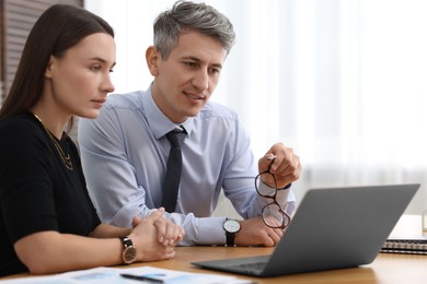 Coworkers working together at table in office