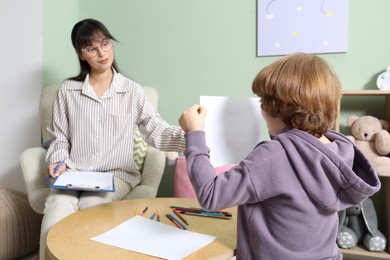 Psychologist evaluating boy's cognitive functions in office