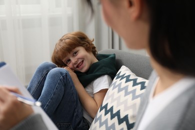 Little boy having therapy session with psychologist in office