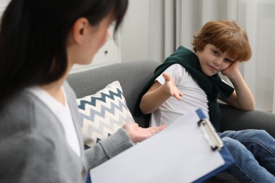 Little boy having therapy session with psychologist in office