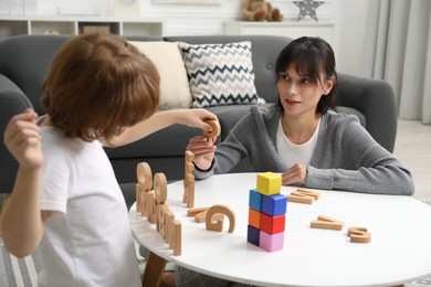 Psychologist evaluating boy's cognitive functions at table in office, selective focus