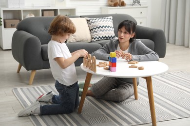 Psychologist evaluating boy's cognitive functions at table in office