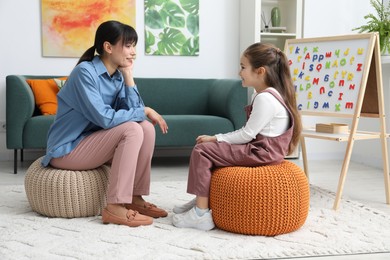 Photo of Little girl having consultation with psychologist in office