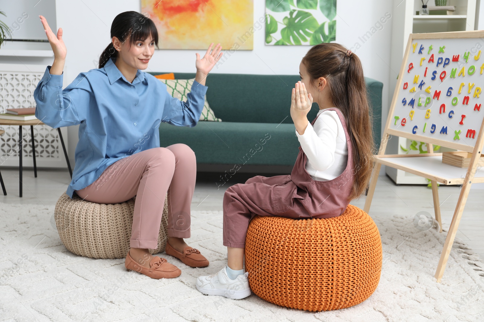 Photo of Little girl having consultation with psychologist in office