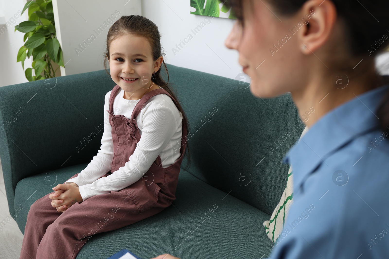 Photo of Little girl having consultation with psychologist in office